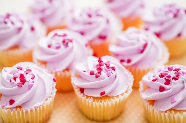 Cupcakes con crema rosa y chispas de corazón — Foto de Stock