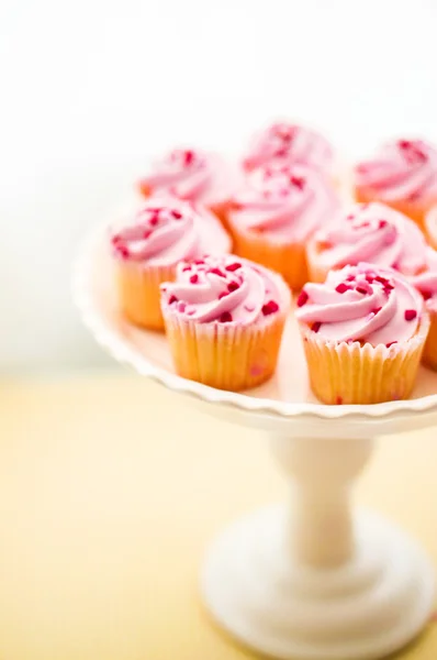 Cupcakes con crema rosa y chispas de corazón — Foto de Stock