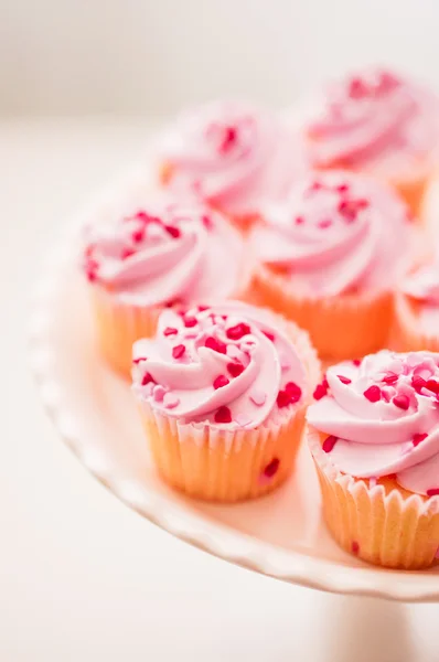 Cupcakes com creme rosa e polvilhas de coração — Fotografia de Stock