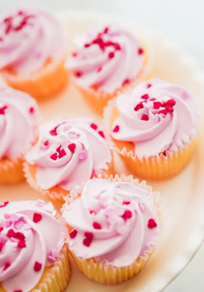 Cupcake con crema rosa e spruzzi di cuore — Foto Stock