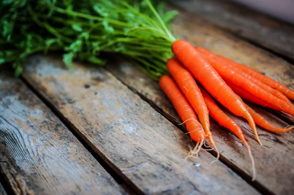 Farm raised organic carrots on wooden background — Stock Photo, Image