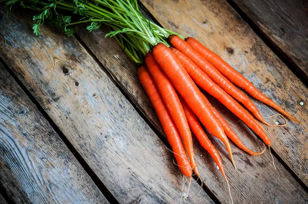 Farm raised organic carrots on wooden background — Stock Photo, Image