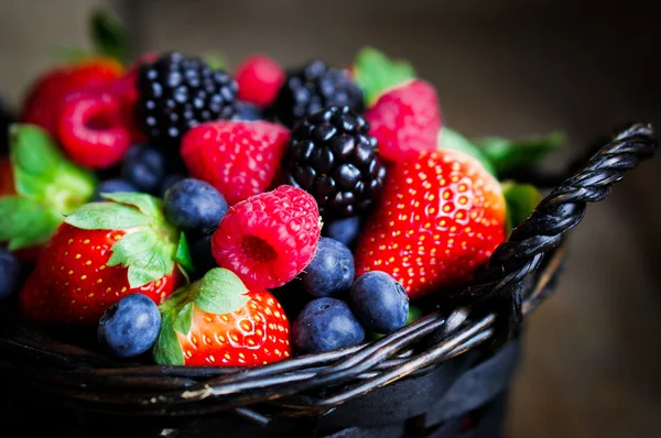 Змішайте свіжі ягоди в кошику на сільському дерев'яному фоні — стокове фото
