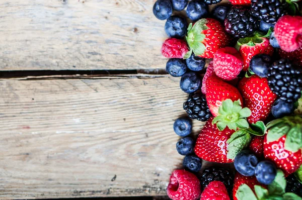 Mix di bacche su sfondo rustico in legno — Foto Stock