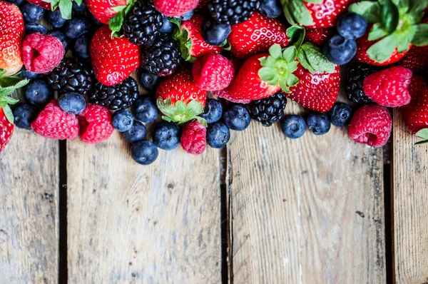 Mix of berries on rustic wooden background — Stock Photo, Image