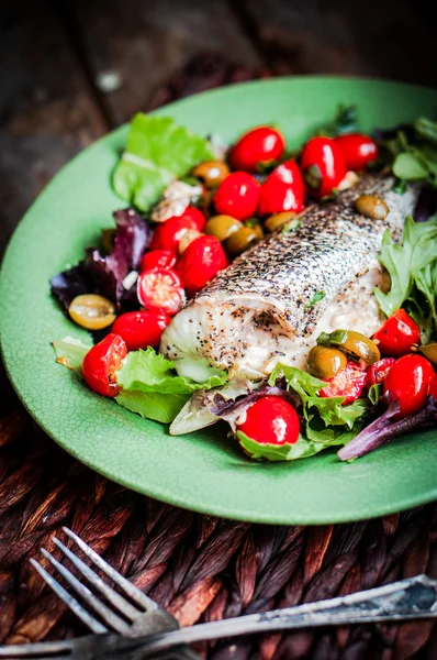 Seabass al horno con tomates y albahaca sobre fondo rústico de madera —  Fotos de Stock