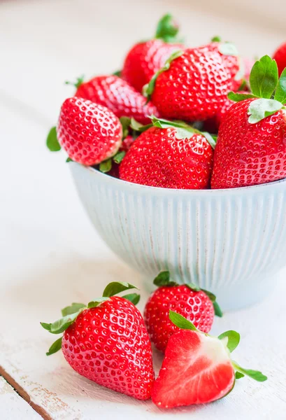 Closeup of strawberries in a bowl on wooden backgorund — Stock Photo, Image