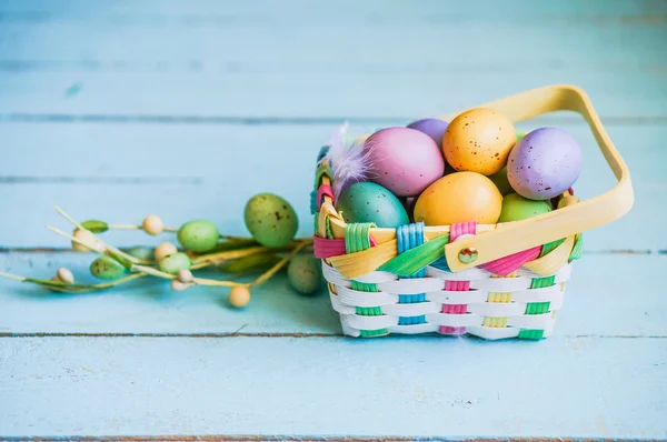 Easter eggs in the basket on blue wooden background — Stock Photo, Image