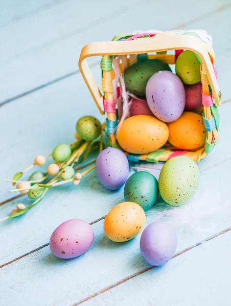 Easter eggs in the basket on blue wooden background — Stock Photo, Image