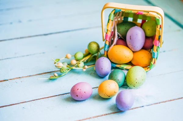 Easter eggs in the basket on blue wooden background — Stock Photo, Image
