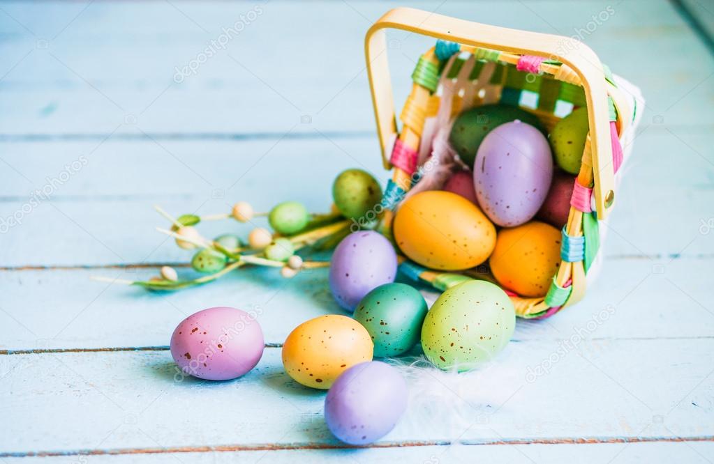 Easter eggs in the basket on blue wooden background