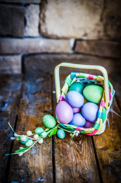 Easter eggs in the basket on rustic wooden background — Stock Photo, Image