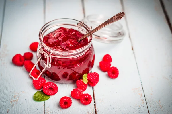 Raspberry jam in a jar on wooden background — Stock Photo, Image