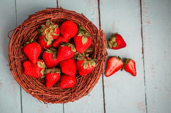 Strawberries in the basket on wooden background — Stock Photo, Image