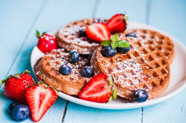 Bütün taneli gözleme mavi ahşap zemin üzerinde meyveleri ile