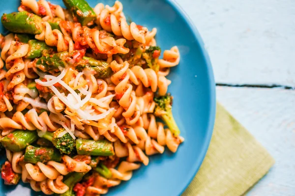 Pasta with vegetables and cheese on wooden background — Stock Photo, Image