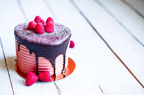 Chocolate cake with raspberries on wooden background — Stock Photo, Image