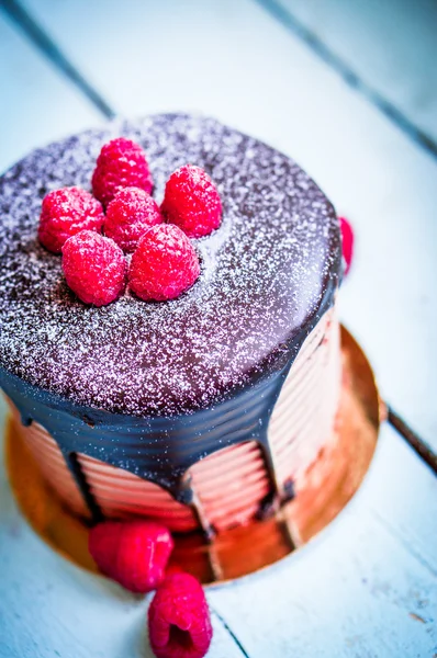 Chocolate cake with raspberries on wooden background — Stock Photo, Image