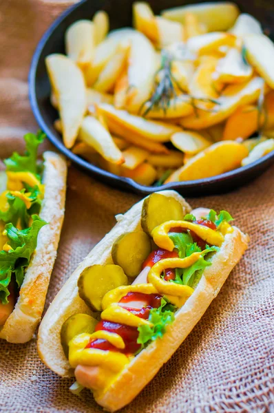 Hot Dogs com batatas fritas na frigideira em fundo de madeira — Fotografia de Stock