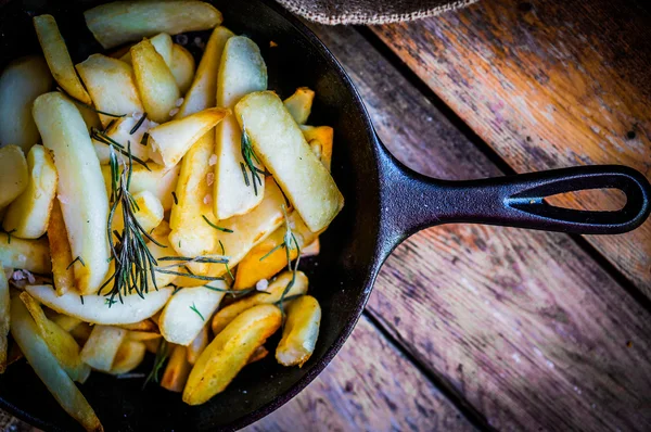 Hjemmelavede pommes frites med rosmarin og salt i støbejernstegepande - Stock-foto