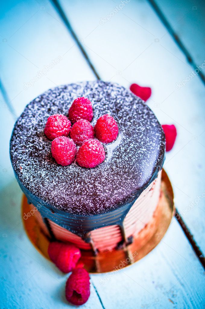 Chocolate cake with raspberries on wooden background