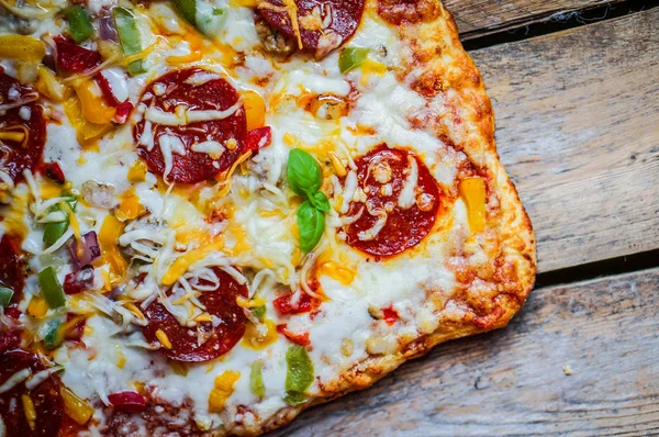 Square pepperoni pizza on rustic wooden background — Stock Photo, Image