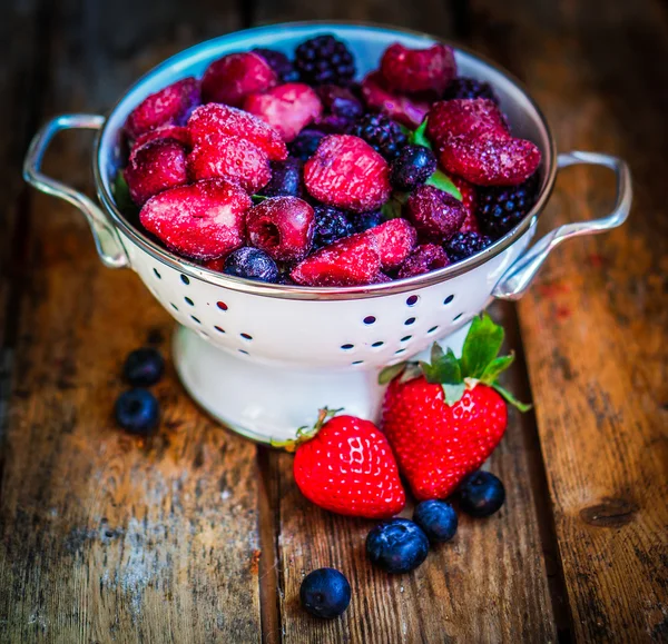 Gefrorene Beeren auf rustikalem Holzgrund — Stockfoto