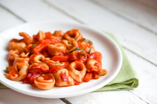 Tortellini primavera parmesan in marinara sauce on wooden rustic — Stock Photo, Image