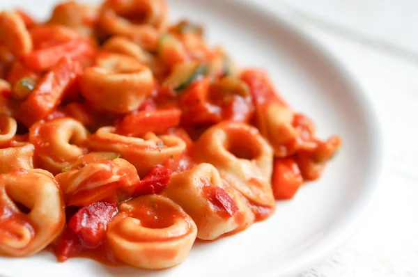 Tortellini primavera parmesan i marinara sås på trä rustika — Stockfoto