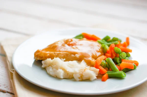 Oven baked chicken in gravy with mashed potatoes and vegetables — Stock Photo, Image