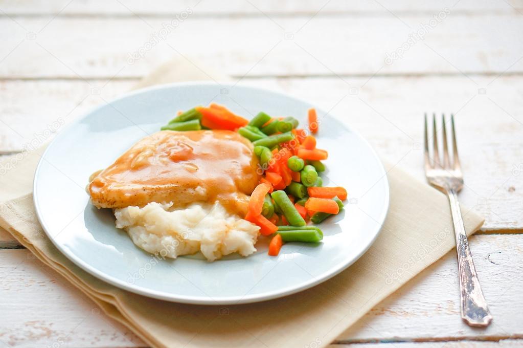 Oven baked chicken in gravy with mashed potatoes and vegetables Stock