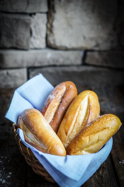 Broodjes in de mand op rustieke houten achtergrond — Stockfoto