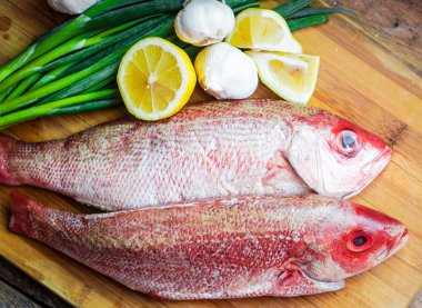 Fresh red snapper preparation with lemon and vegetables clipart