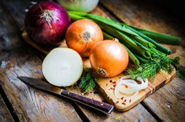 Colorful onions and garlic on rustic wooden background clipart
