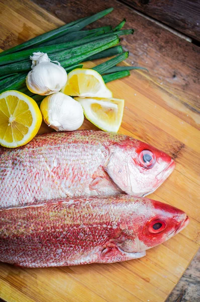 Fresh red snapper preparation with lemon and vegetables — Stock Photo, Image