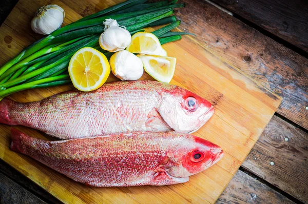 Frisk rød snapper forberedelse med citron og grøntsager - Stock-foto