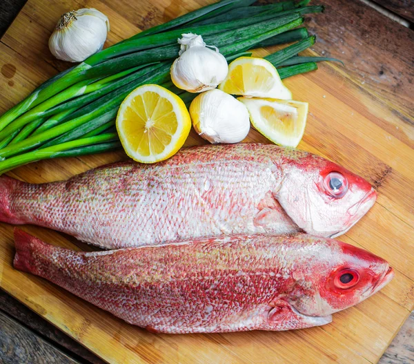 Frisk rød snapper forberedelse med citron og grøntsager - Stock-foto