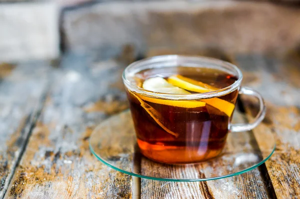 Eine Tasse Tee mit Zitrone auf rustikalem Holzgrund — Stockfoto