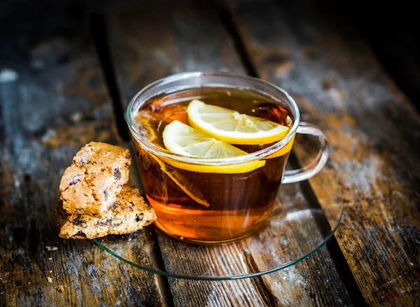 Tea cup with lemon and cookies on rustic wooden background — Stock Photo, Image