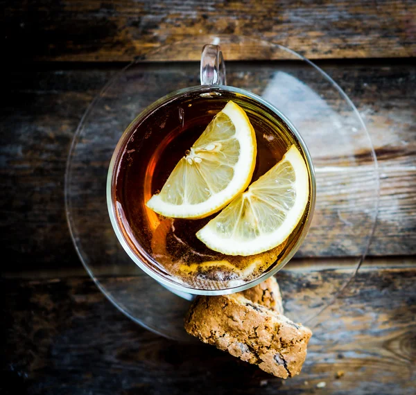 Uma xícara de chá com limão em fundo de madeira rústica — Fotografia de Stock