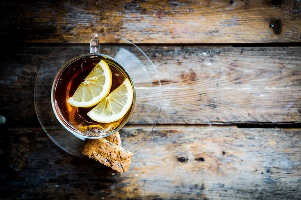 素朴な木製の背景にレモンとお茶のカップ — ストック写真