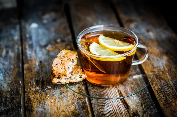 Xícara de chá com limão e biscoitos no fundo de madeira rústica — Fotografia de Stock