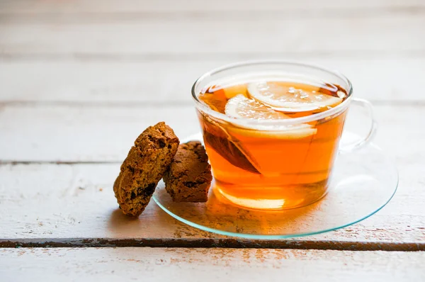 Teetasse mit Zitrone und Keksen auf rustikalem Holzgrund — Stockfoto