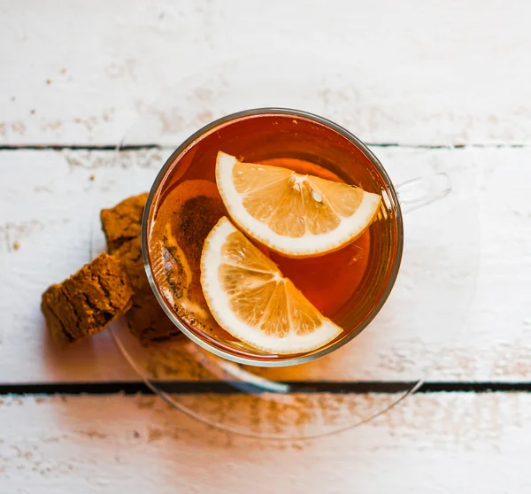 Te kopp med citron och cookies på rustika trä bakgrund — Stockfoto