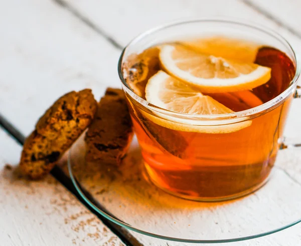Xícara de chá com limão e biscoitos no fundo de madeira rústica — Fotografia de Stock