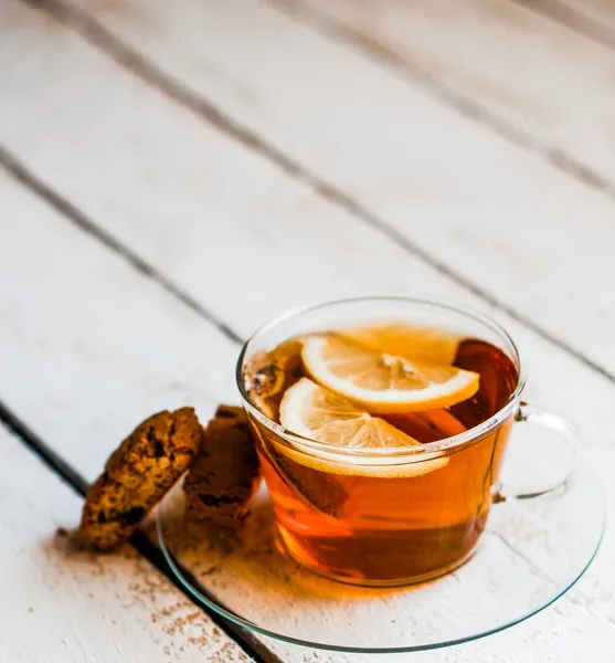 Xícara de chá com limão e biscoitos no fundo de madeira rústica — Fotografia de Stock