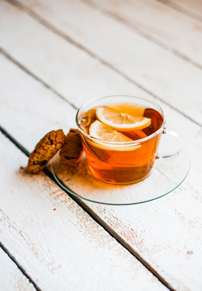 Ένα φλυτζάνι τσάι με λεμόνι και τα cookies σε ρουστίκ ξύλινα φόντο — Φωτογραφία Αρχείου