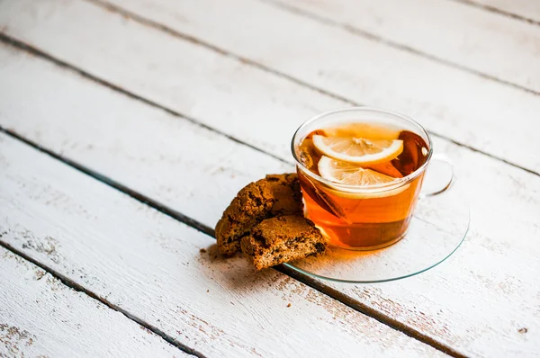 Tea cup with lemon and cookies on rustic wooden background — Stock Photo, Image