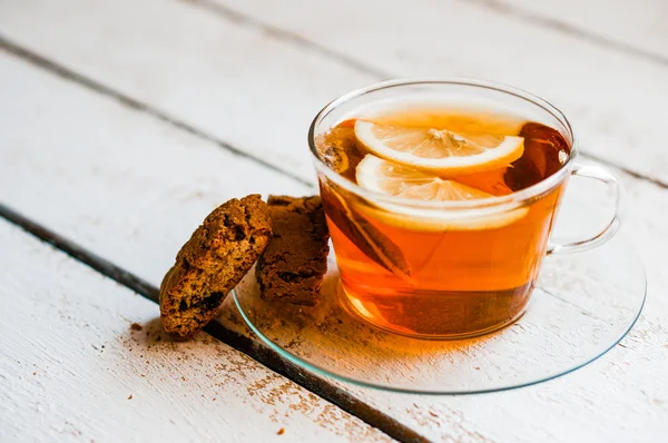 Xícara de chá com limão e biscoitos no fundo de madeira rústica — Fotografia de Stock