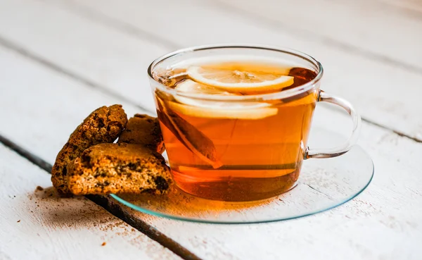 Xícara de chá com limão e biscoitos no fundo de madeira rústica — Fotografia de Stock